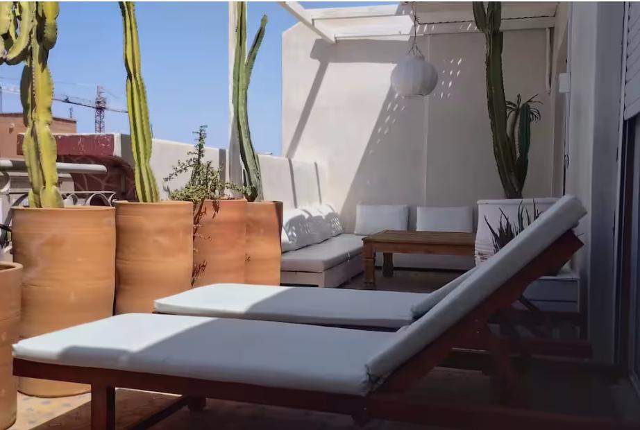 Bains de soleil sur la terrasse privée entourée de cactus, appartement Guéliz Marrakech